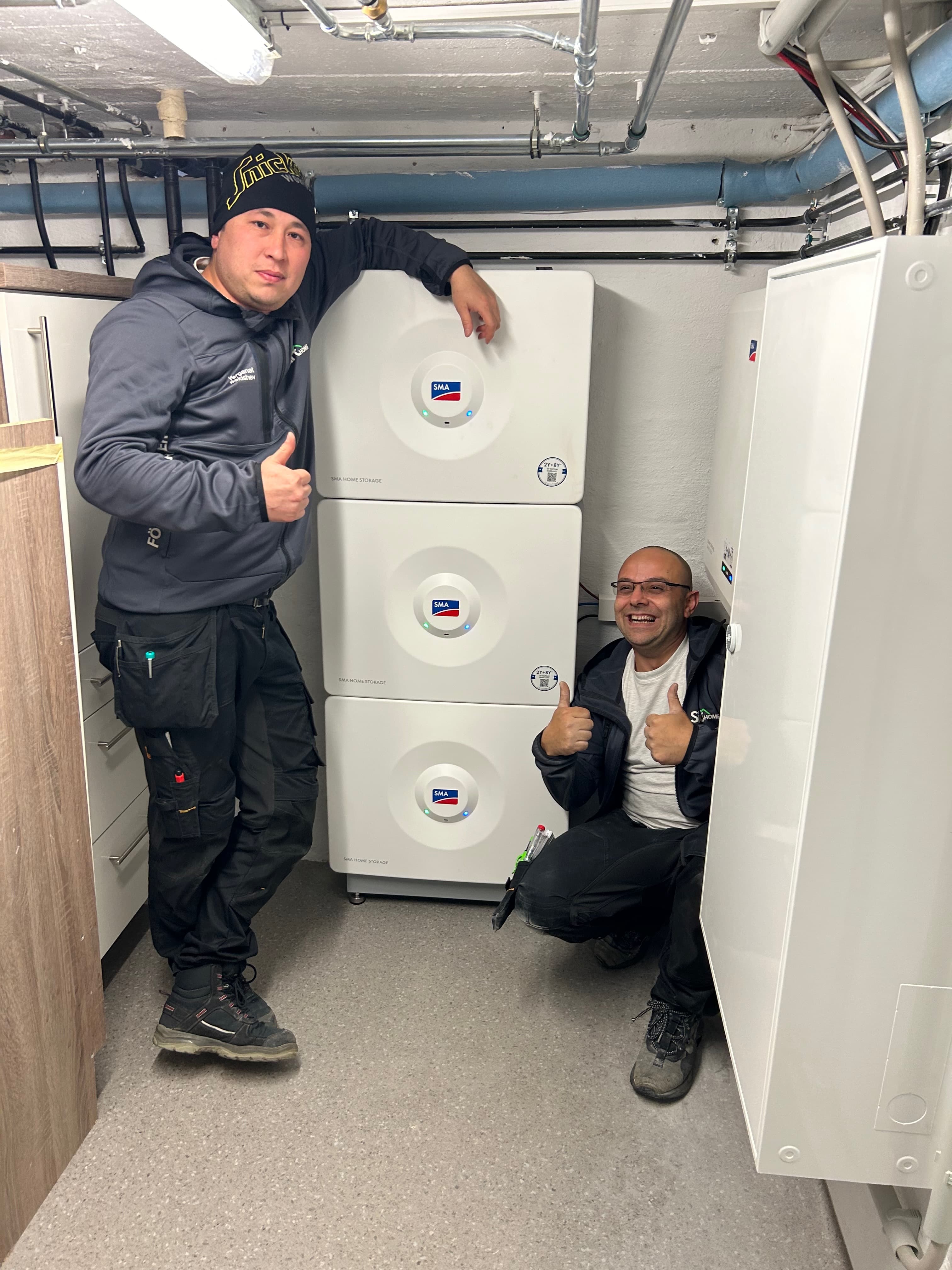 Zwei BSH-Monteure nach erfolgreicher SMA-Speicher-Inbetriebnahme